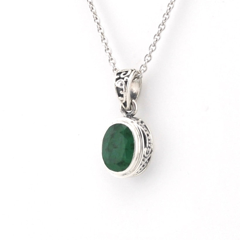 Silver necklace with a green gemstone pendant on a white background