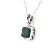 Silver pendant with a green stone on a white background