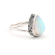 Silver ring with a teardrop-shaped opal stone on a white background