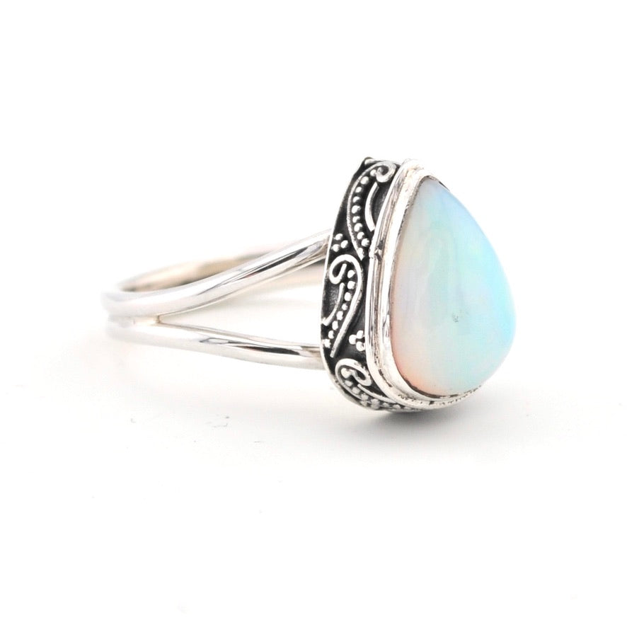 Silver ring with a teardrop-shaped opal stone on a white background