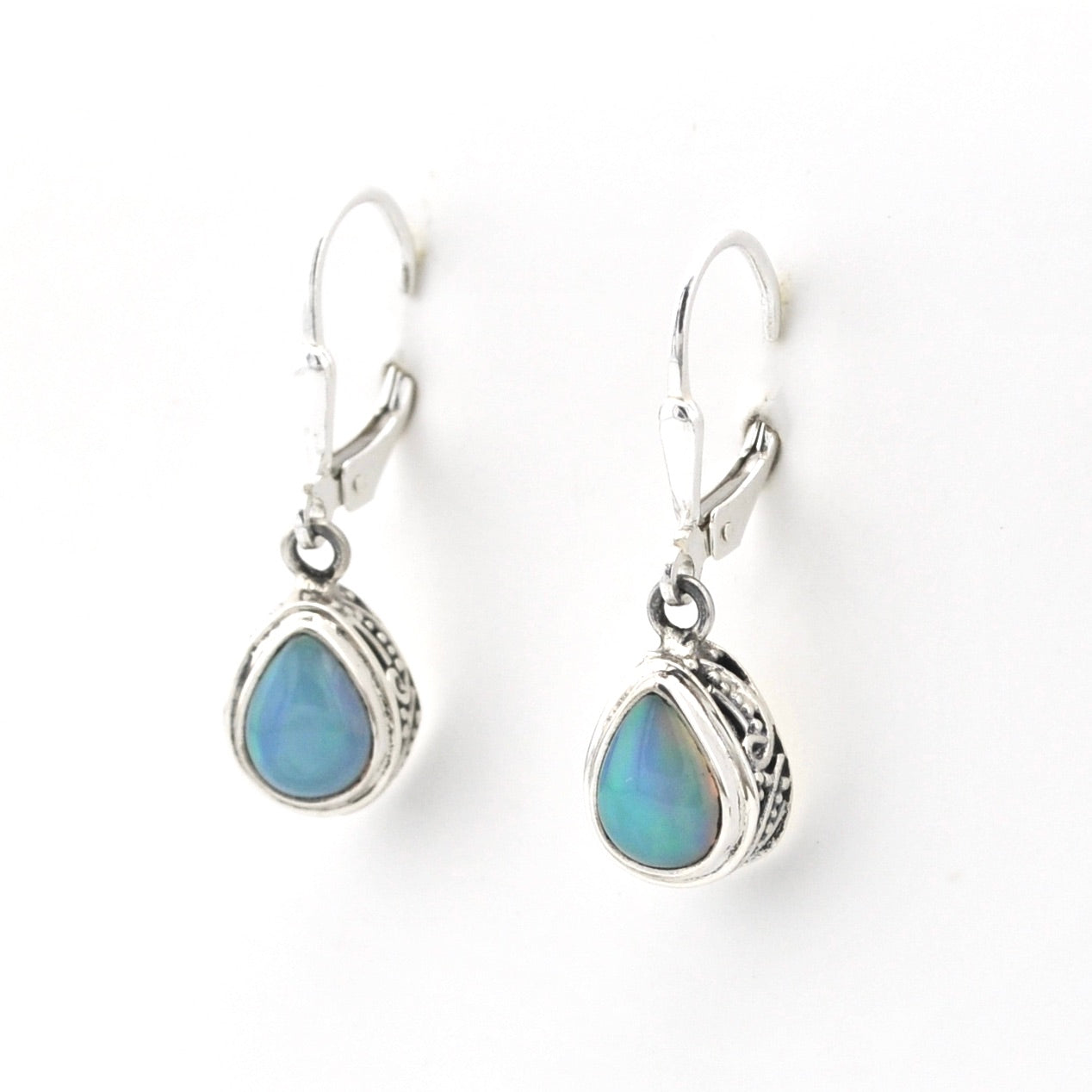 Pair of silver earrings with blue teardrop stones on a white background