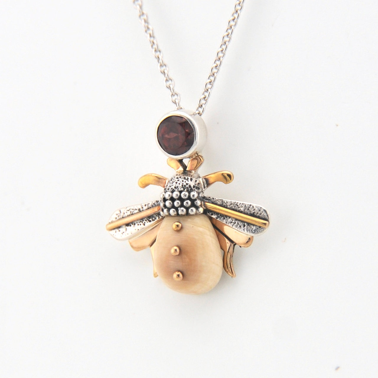 Jewelry pendant with gold and silver design on a white background