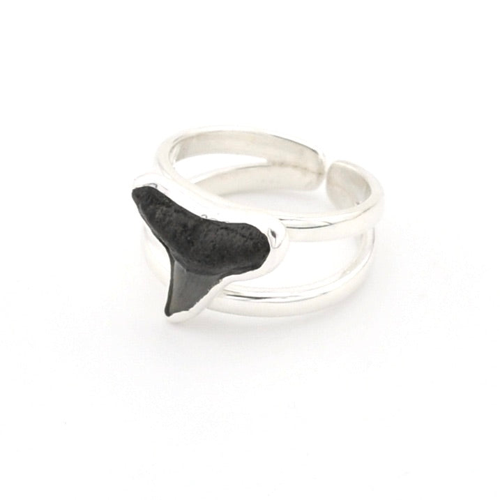 Silver ring with a black shark tooth design on a white background