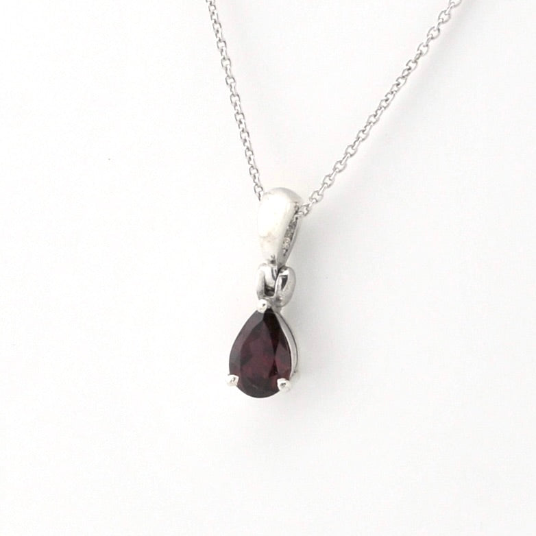 A silver pendant necklace featuring a teardrop-shaped dark red gemstone, displayed on a clean white background.