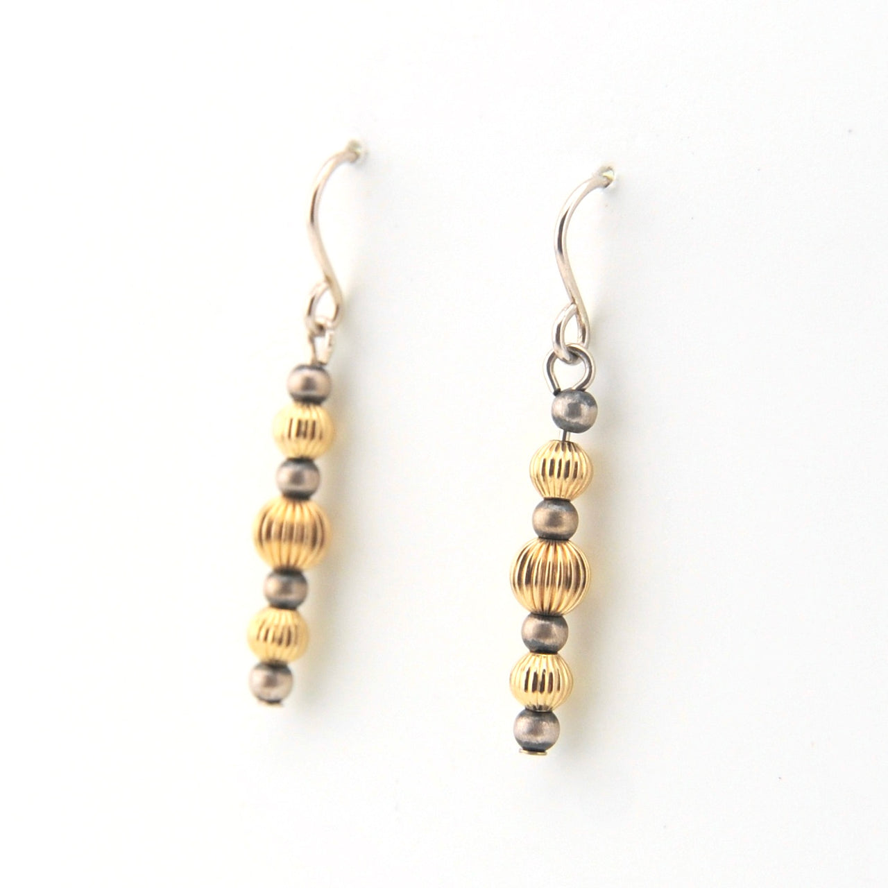 Pair of earrings with gold and silver beads on a white background