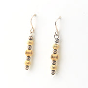 Pair of earrings with gold and silver beads on a white background