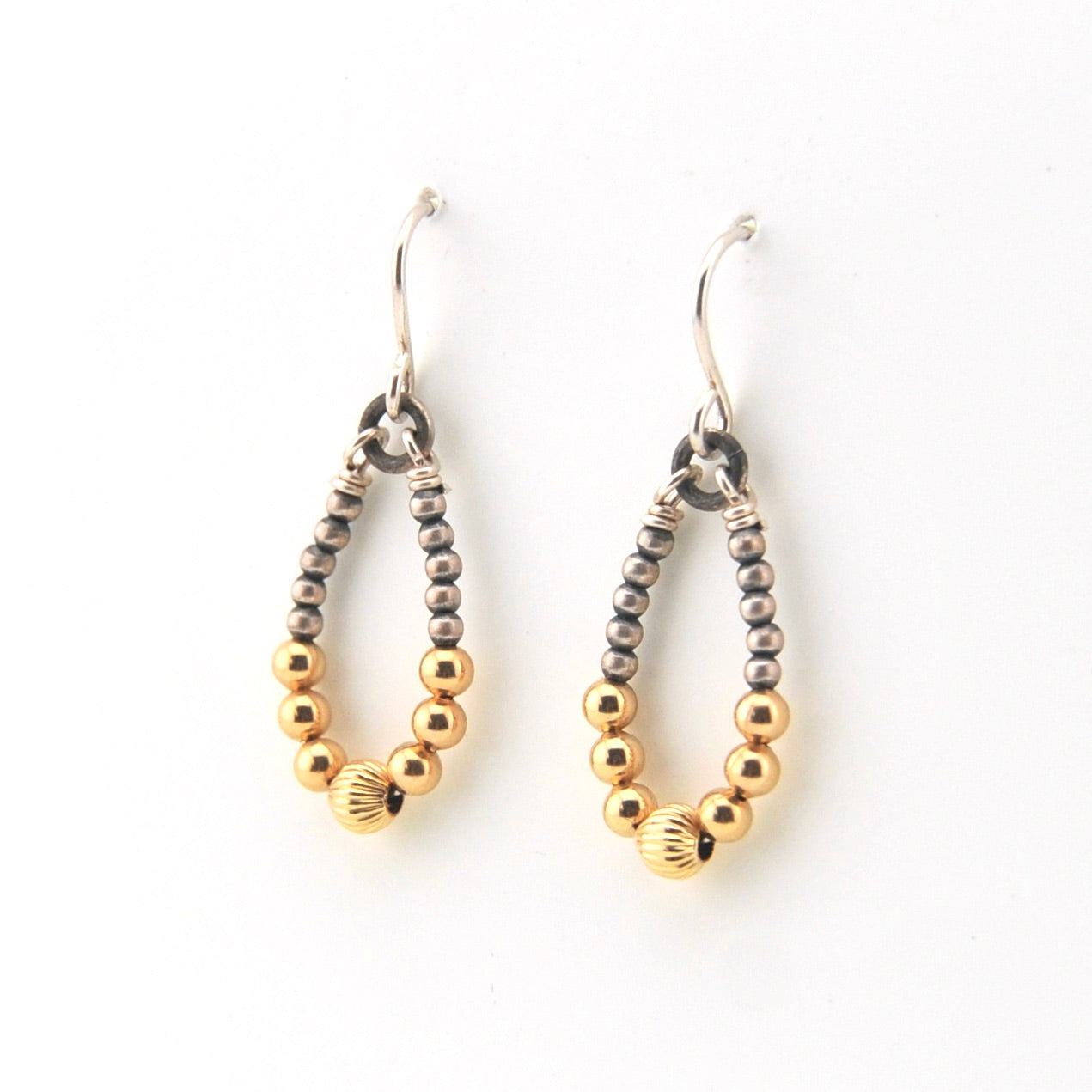 Pair of beaded earrings with gold and silver beads on a white background