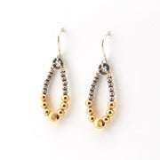 Pair of beaded earrings with gold and silver beads on a white background