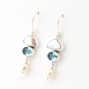 Silver earrings with blue gemstones and pearls on a white background