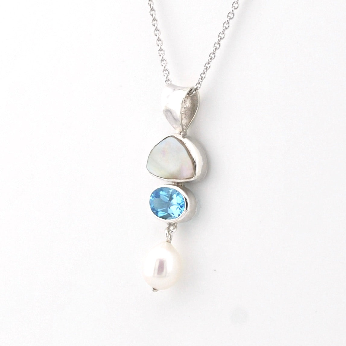 Necklace with a pendant featuring a blue gemstone and pearl on a white background