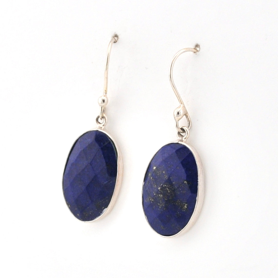 Pair of blue lapis oval earrings with silver on a white background