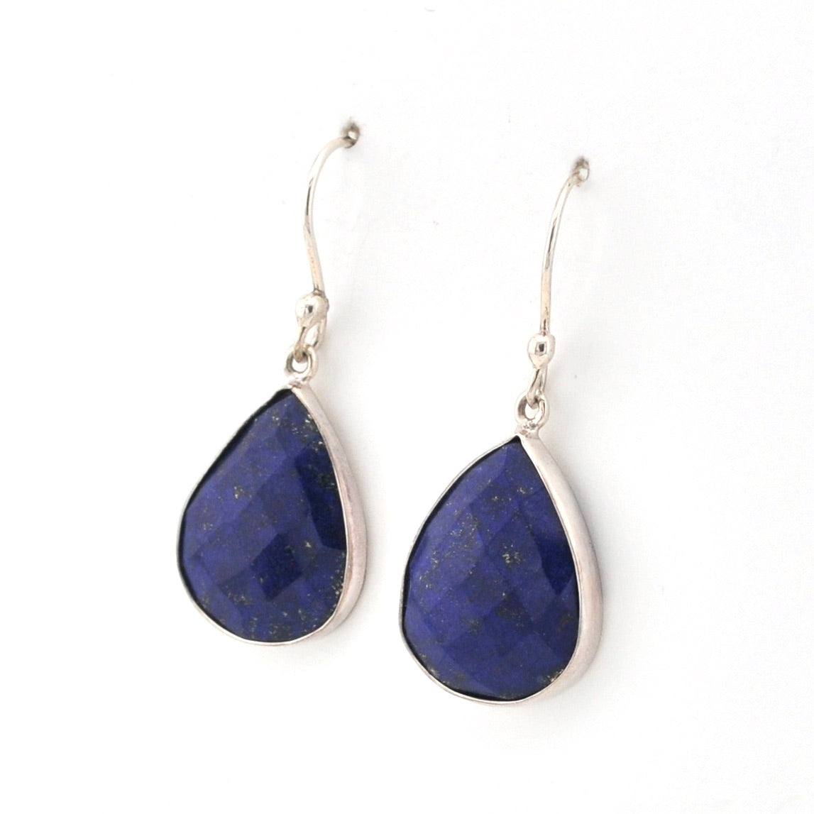 Teardrop-shaped blue lapis earrings with silver hooks on a white background