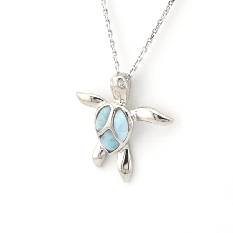 Silver turtle pendant with light blue stone on a white background