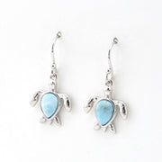 Turtle-shaped earrings with blue gemstones on a white background