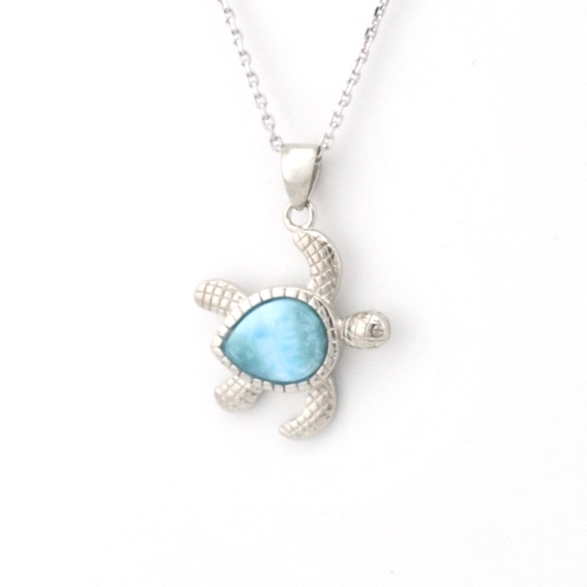 Turtle-shaped pendant with blue stone on a white background