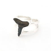 Silver ring with a black shark tooth stone on a white background