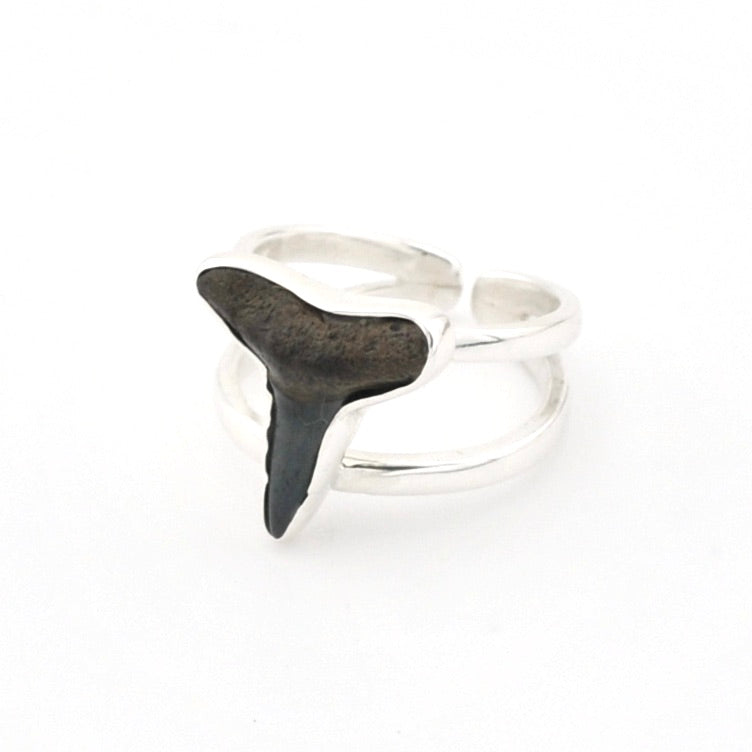Silver ring with a black shark tooth stone on a white background