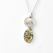 Gold pendant necklace with a green gemstone on a white background