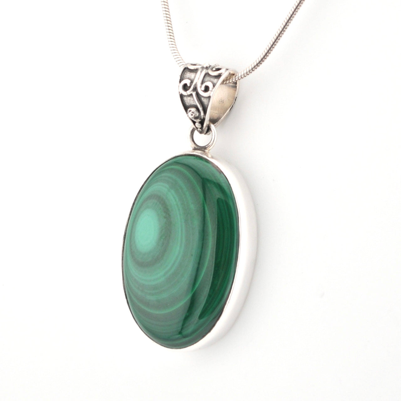 Green stone pendant on a silver chain against a white background