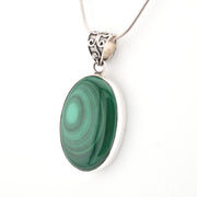 Green stone pendant on a silver chain against a white background