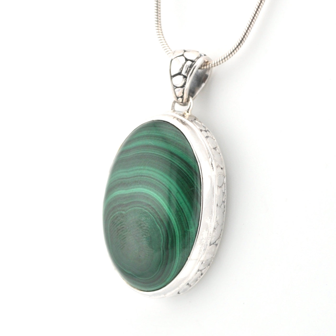 Silver pendant with a green stone on a white background