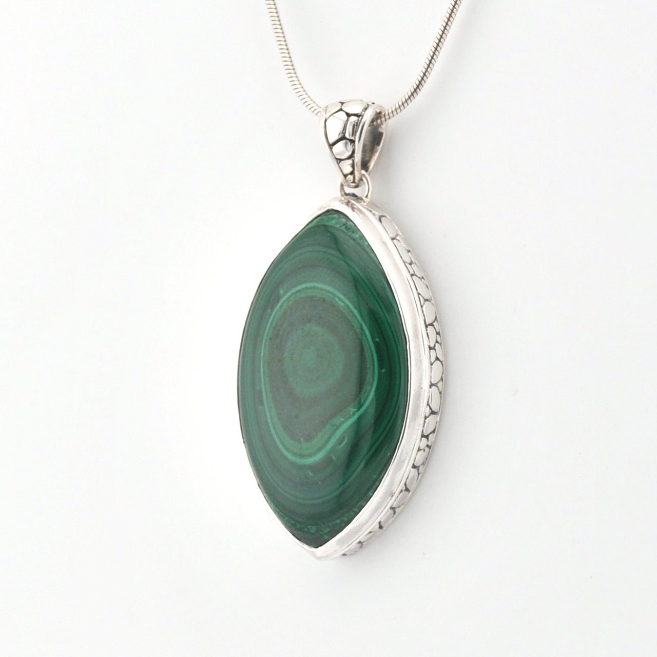 Green stone pendant with silver frame on a white background