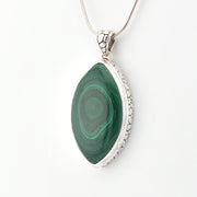 Green stone pendant with silver frame on a white background
