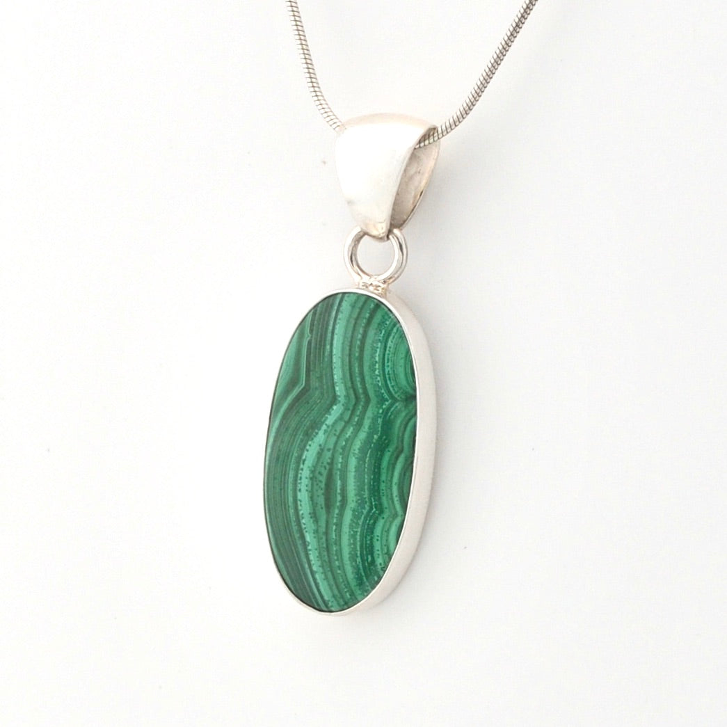 Green malachite pendant on a silver chain against a white background