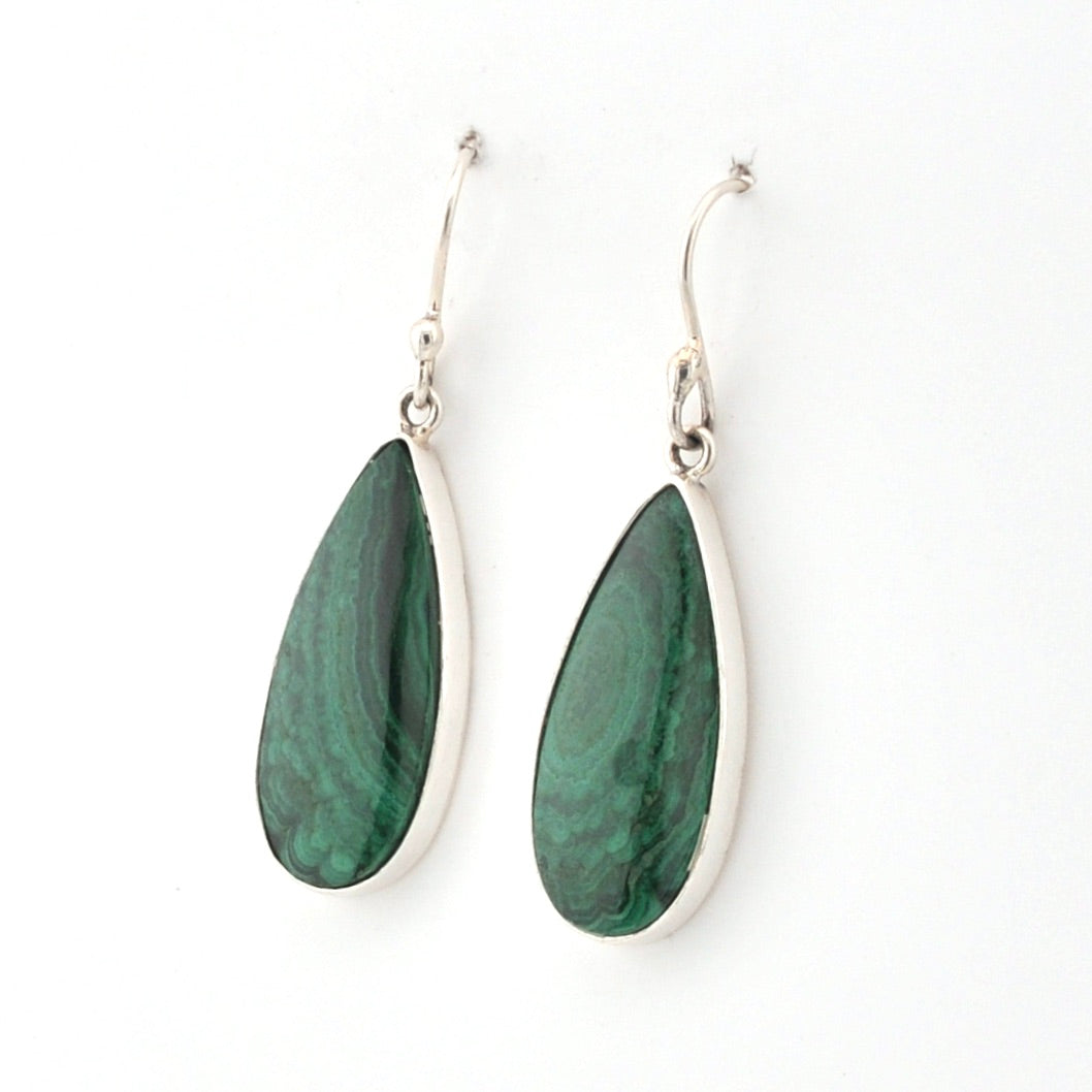 Teardrop-shaped green earrings with silver hooks on a white background