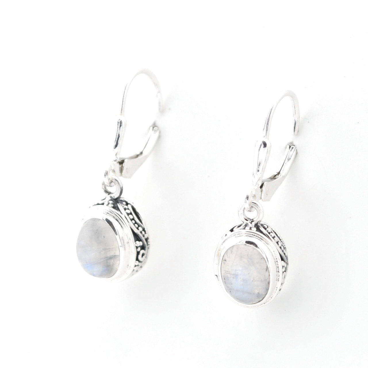 Pair of silver earrings with oval gemstones on a white background