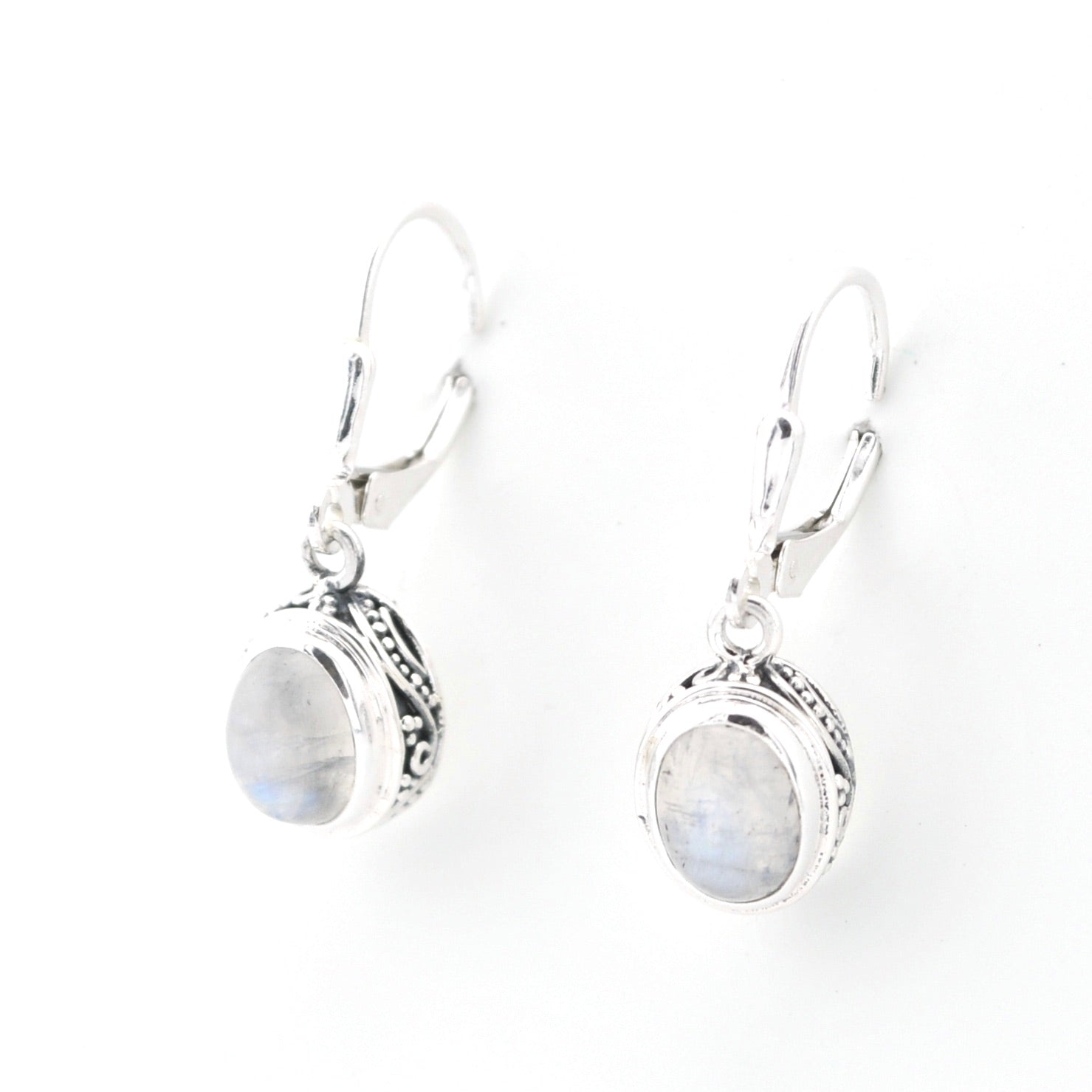 Pair of silver earrings with oval gemstones on a white background