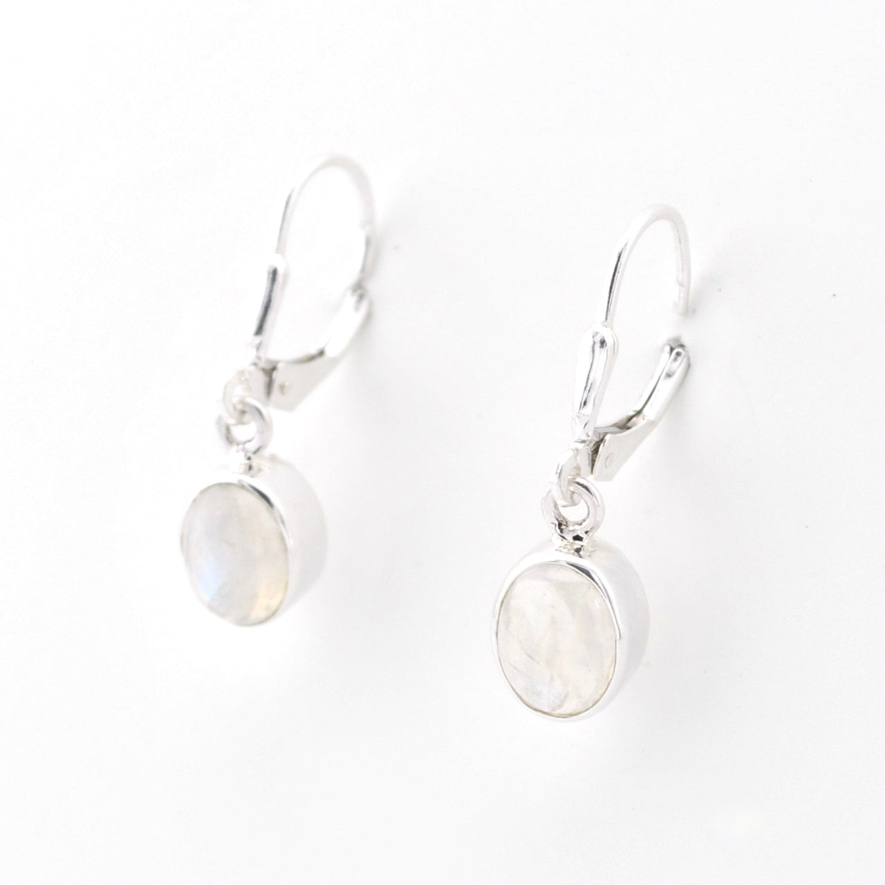 Silver earrings with round moonstone stones on a white background