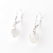 Silver earrings with round moonstone stones on a white background