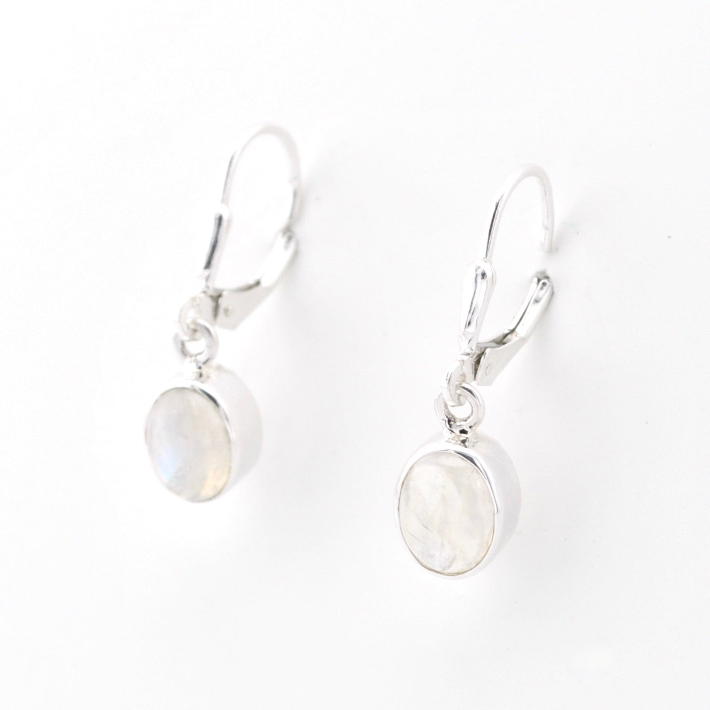 Silver earrings with round moonstone stones on a white background