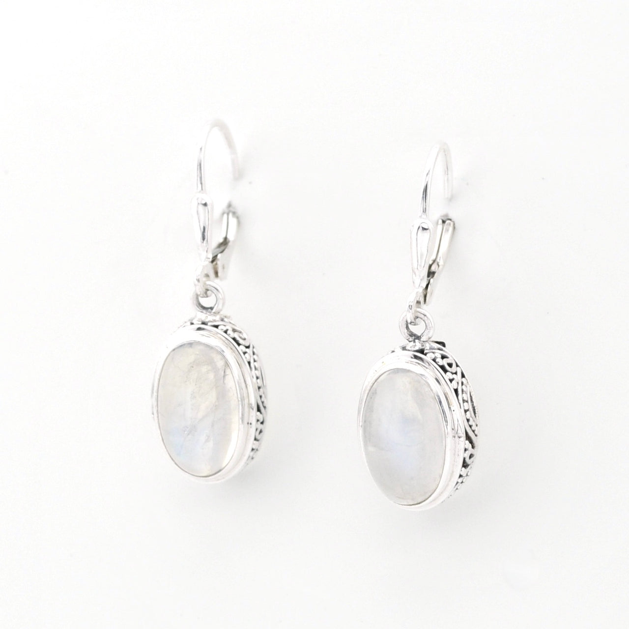 Pair of silver earrings with oval gemstones on a white background