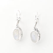 Pair of silver earrings with oval gemstones on a white background