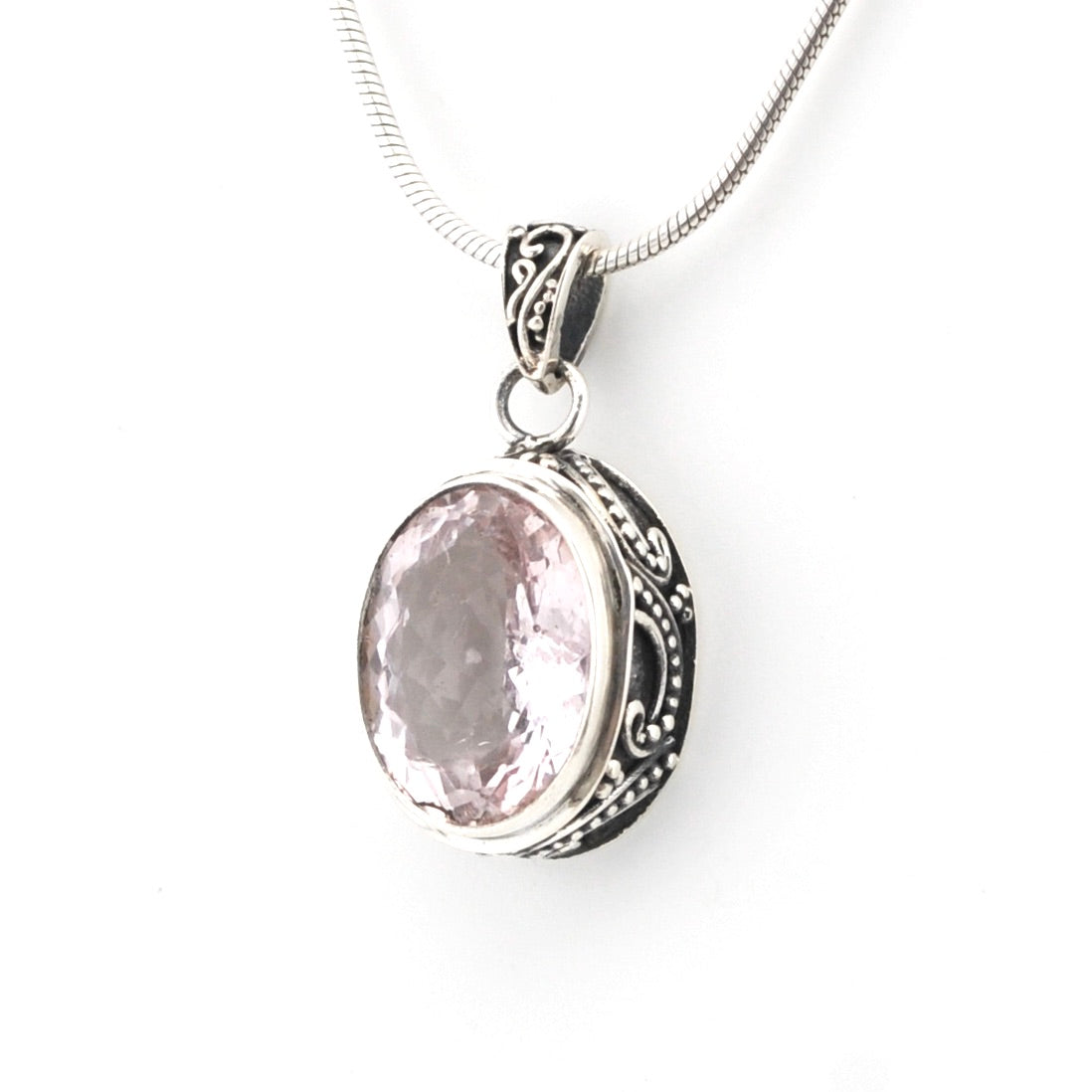 Silver pendant with a pink gemstone on a white background