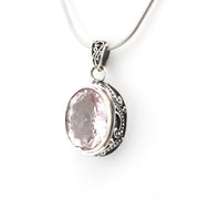 Silver pendant with a pink gemstone on a white background
