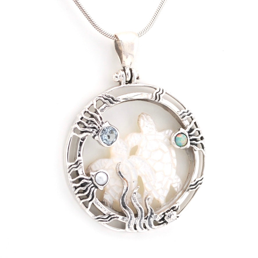 Silver pendant with a shell and small stones on a white background