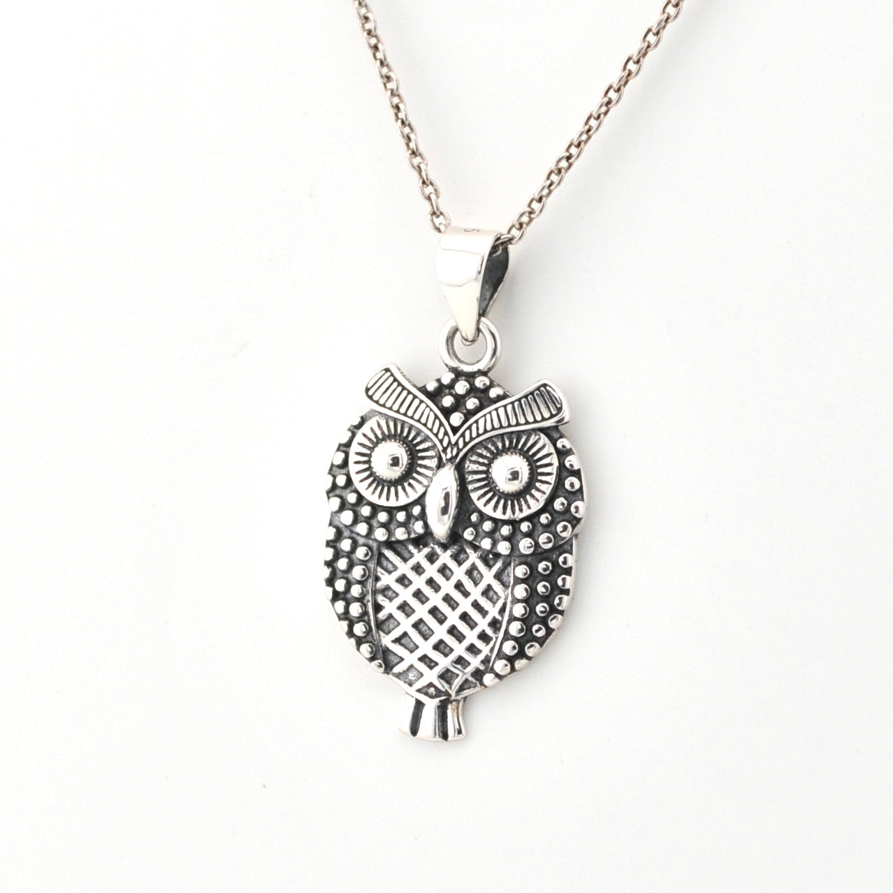 Silver owl pendant necklace on a white background