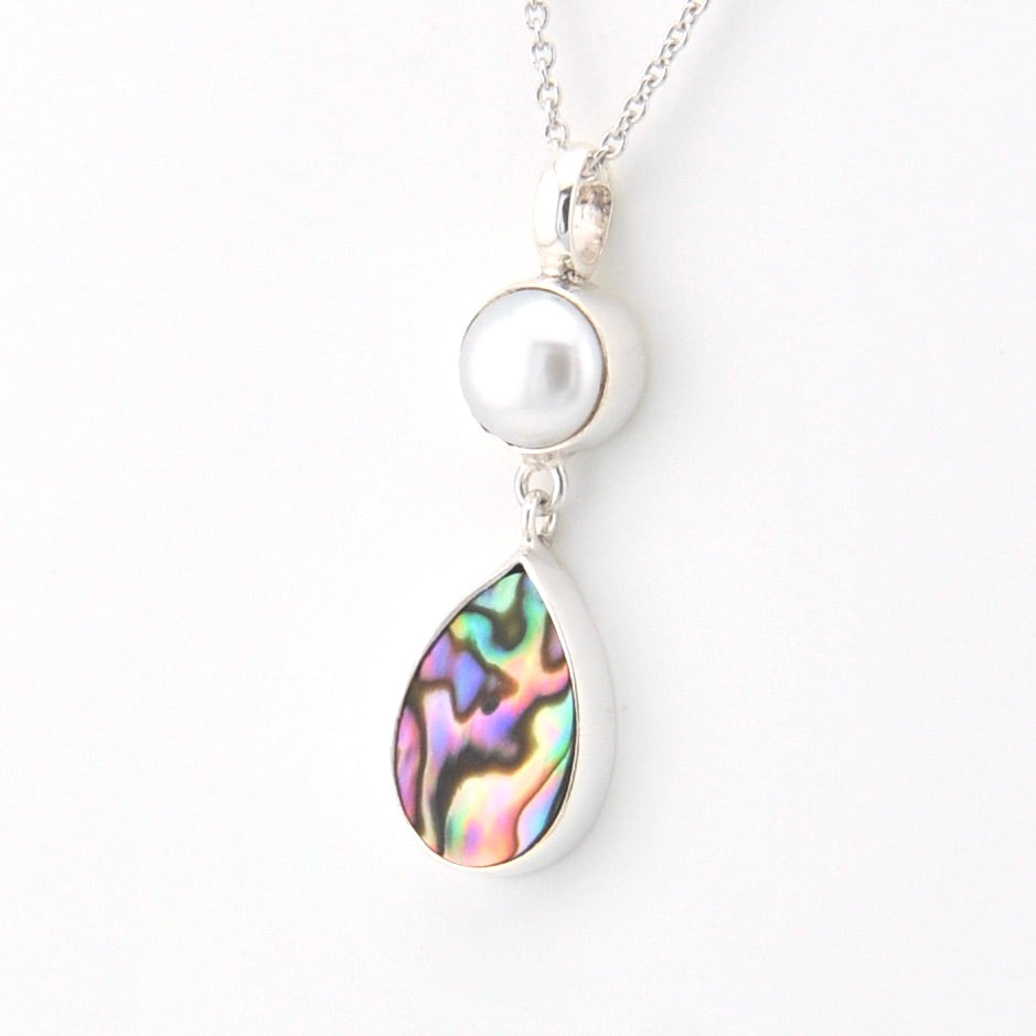 Necklace with a pearl and abalone shell pendant on a white background