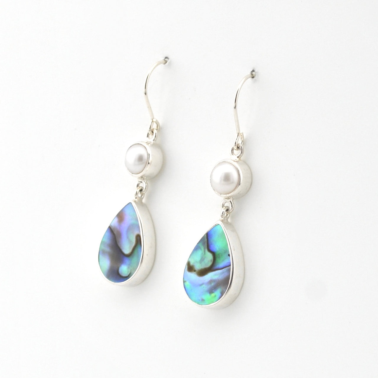 Silver earrings with teardrop-shaped abalone shell drops on a white background