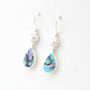 Silver earrings with teardrop-shaped abalone shell drops on a white background
