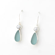 Pair of earrings with light blue teardrop-shaped stones and pearl-like tops on a white background