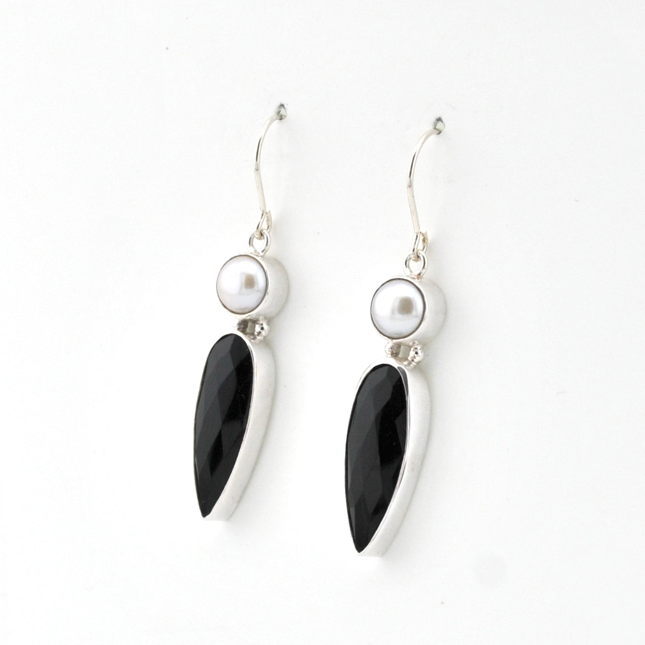Pair of earrings with black teardrop-shaped stones and pearl-like beads on a white background