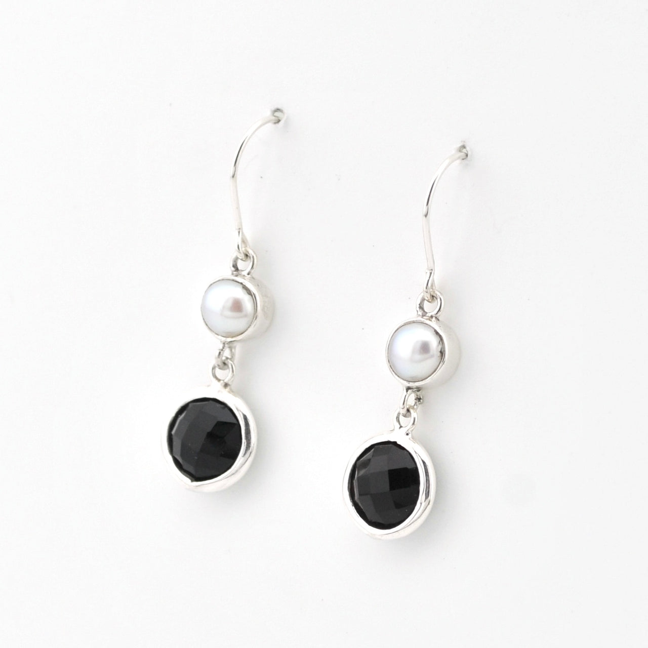 Pair of earrings with black stones and pearls on a white background