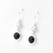 Pair of earrings with black stones and pearls on a white background