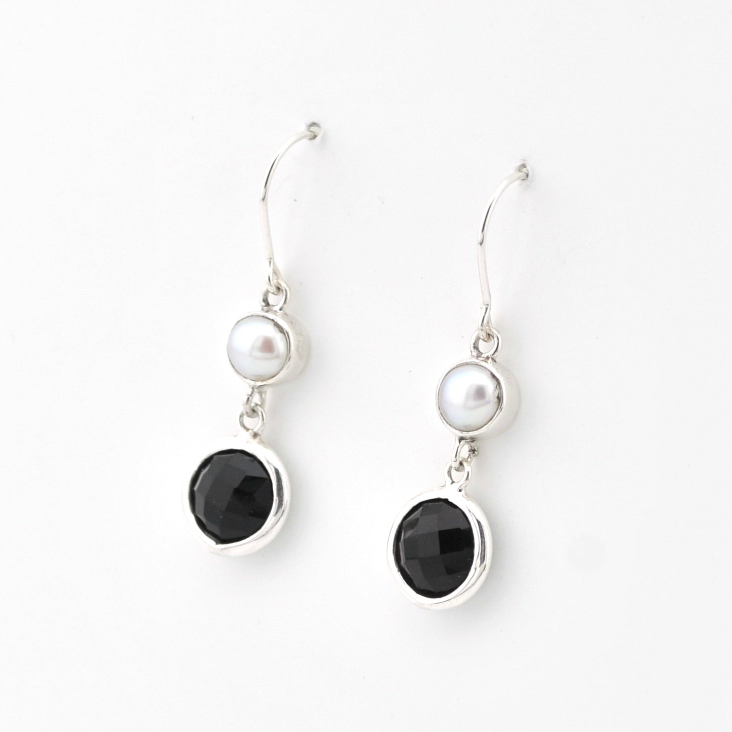 Pair of earrings with black stones and pearls on a white background
