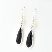 Black teardrop earrings with white stones on a white background