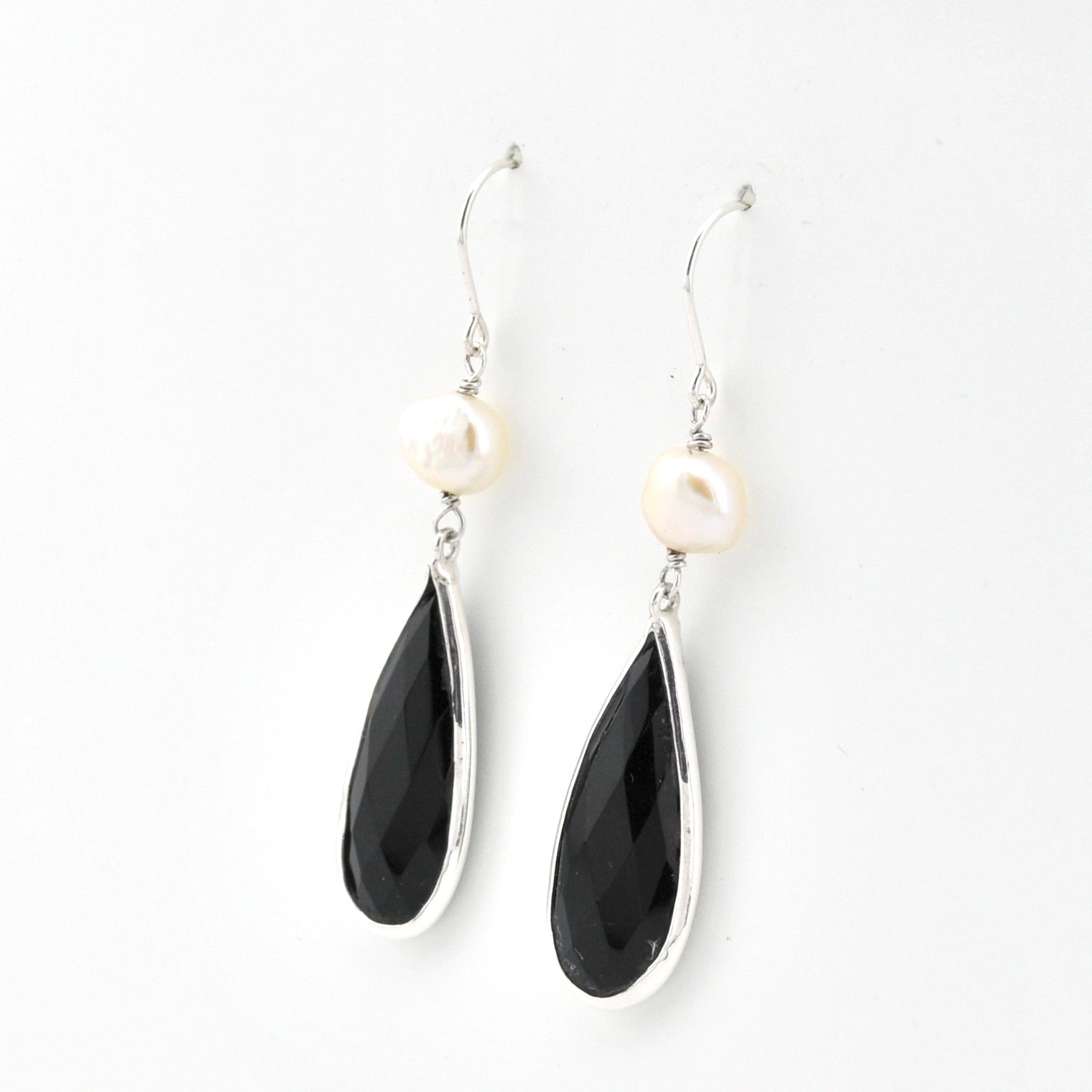 Black teardrop earrings with white stones on a white background